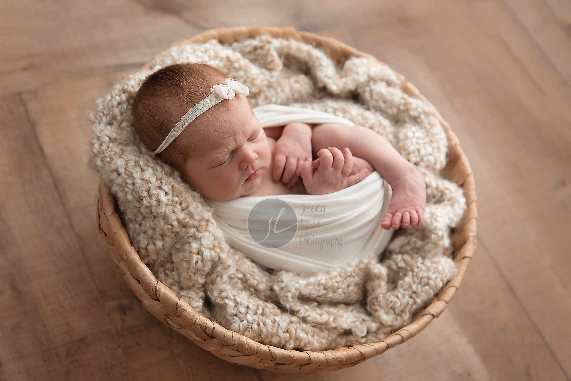 baby in a basket with wood floor